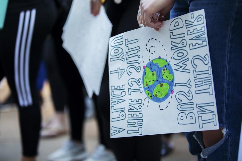 Hand of student holding sign with text and picture of globe